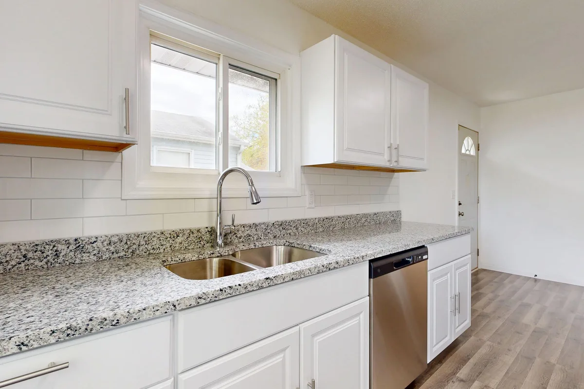 Remodeled white kitchen with granite counters